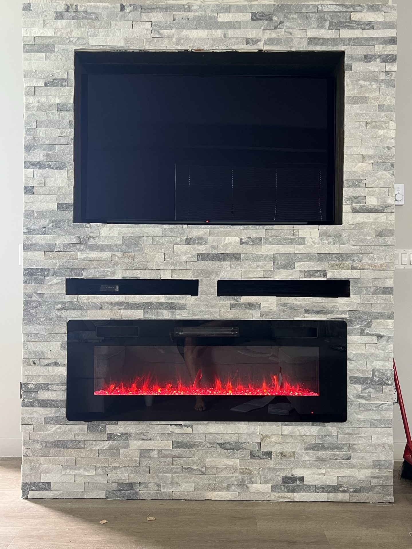 Finished stone fireplace feature wall with mounted TV